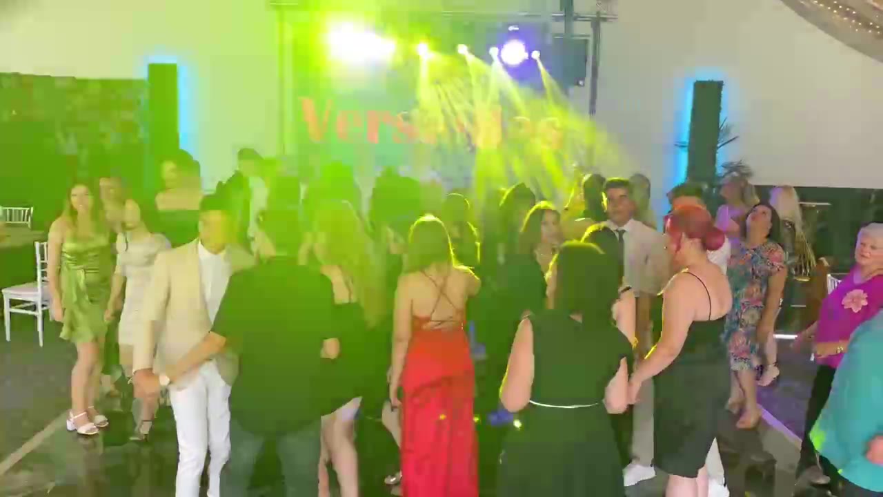 Invitați dansând pe ringul de dans în fața scenei cu lumini colorate, petrecere în zona Sibiu
